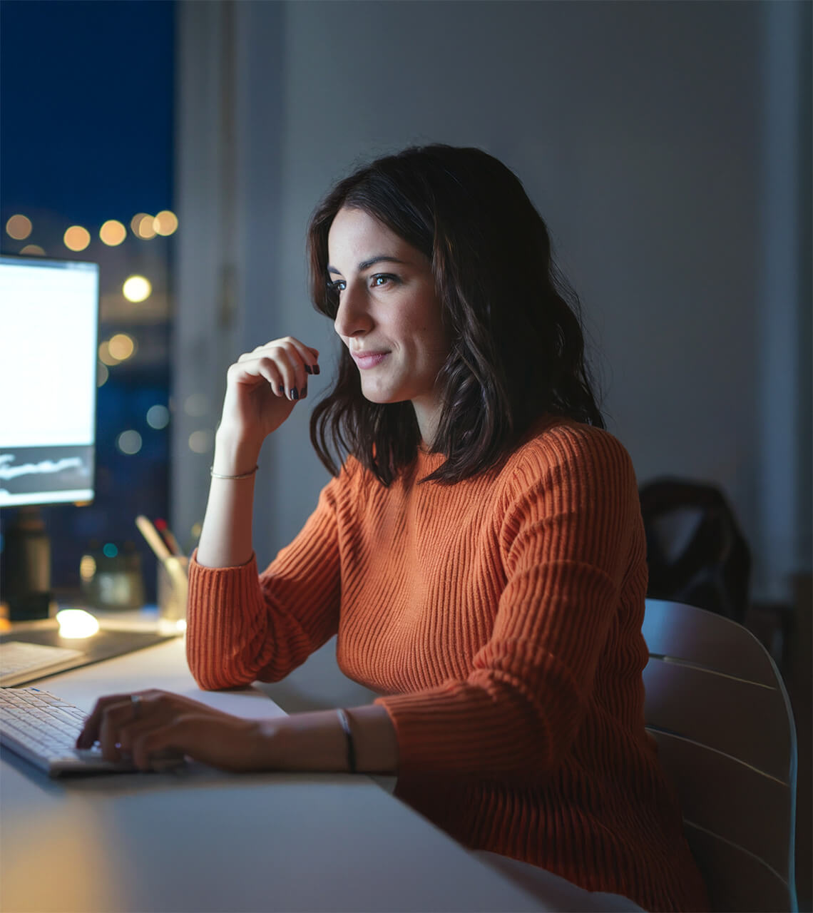 Female content creator looking at monitor at night